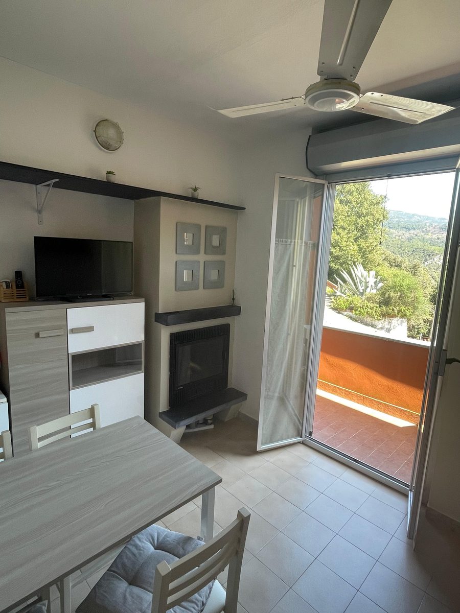Séjour de Sabbia avec cheminée et porte sur le balcon